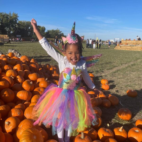 5 Girl in costume in pile of pumpkins